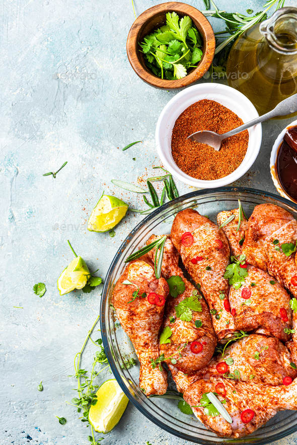 Marinating Raw Chicken Drumsticks in Herbs and Spices Stock Photo by merc67